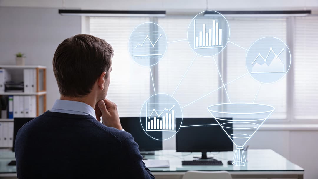 A businessman looking at a digital interface showing various financial charts and a sales funnel diagram.